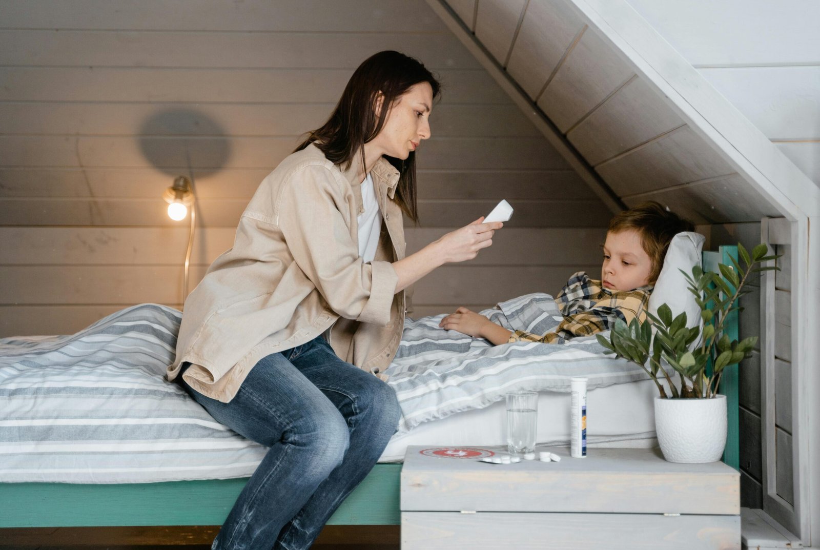 A parent checking a toddler's temperature during common childhood illness