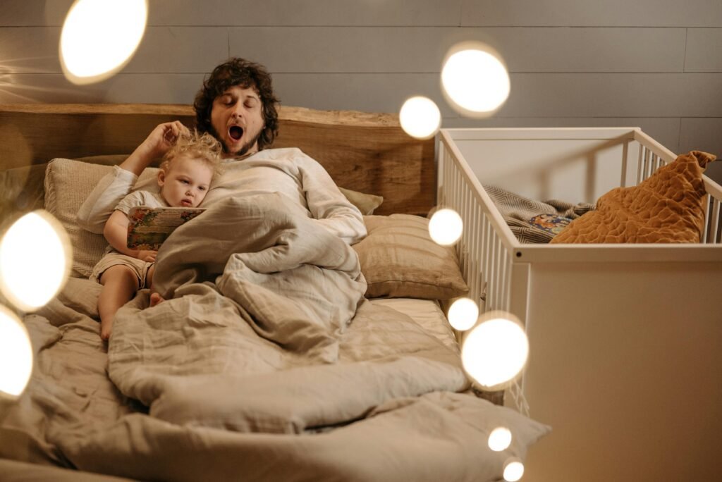 A father and his young child sharing a bedtime story in a cozy, softly-lit bedroom.